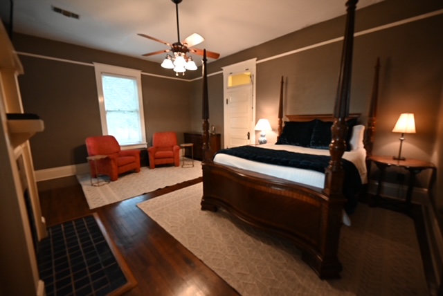 a bedroom with a wood floor and a ceiling fan